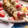 Colorful Banana Split Kabobs with fruits and ice cream on skewers