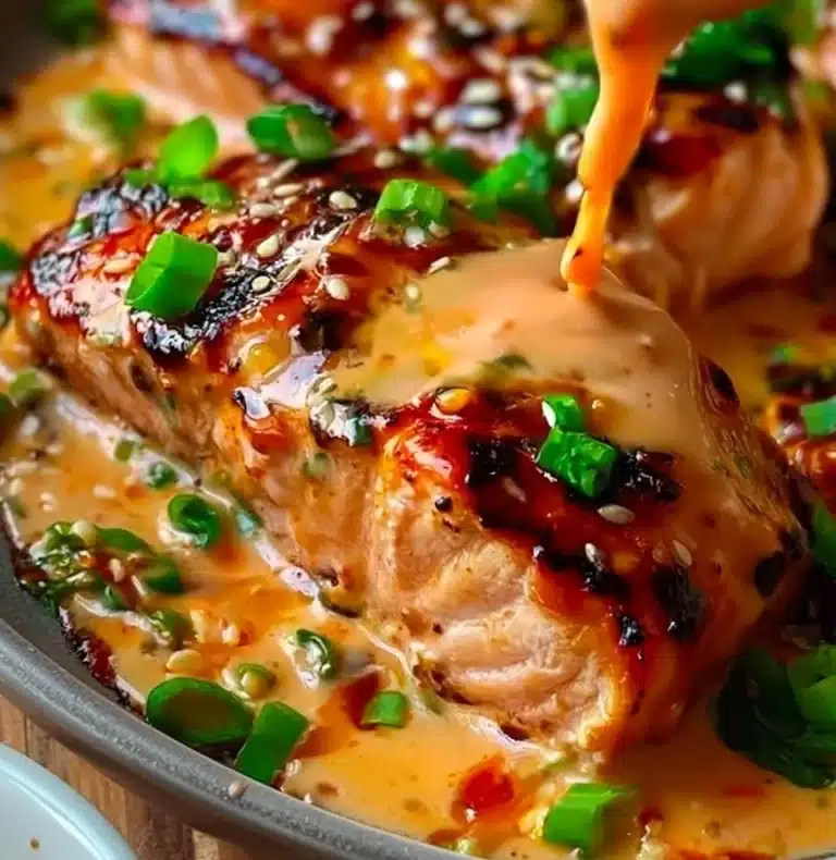 Bang Bang Salmon dish garnished with fresh herbs and spicy sauce