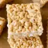 Brown butter rice krispies treats on a white plate, drizzled with caramel.