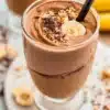 Chocolate Peanut Butter Banana Smoothie in a glass with a straw