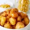 Golden brown corn fritters served on a plate with dipping sauce