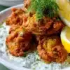 Plate of golden crispy oysters garnished with lemon and herbs