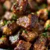 Plated garlic butter steak bites garnished with herbs
