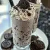 Delicious homemade Oreo milkshake topped with whipped cream and crushed Oreos