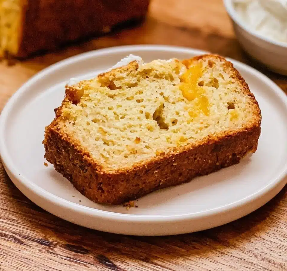 Homemade Peach Bread fresh out of the oven with slices on a wooden table