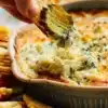 Delicious homemade pickle dip served in a bowl with crackers and veggies