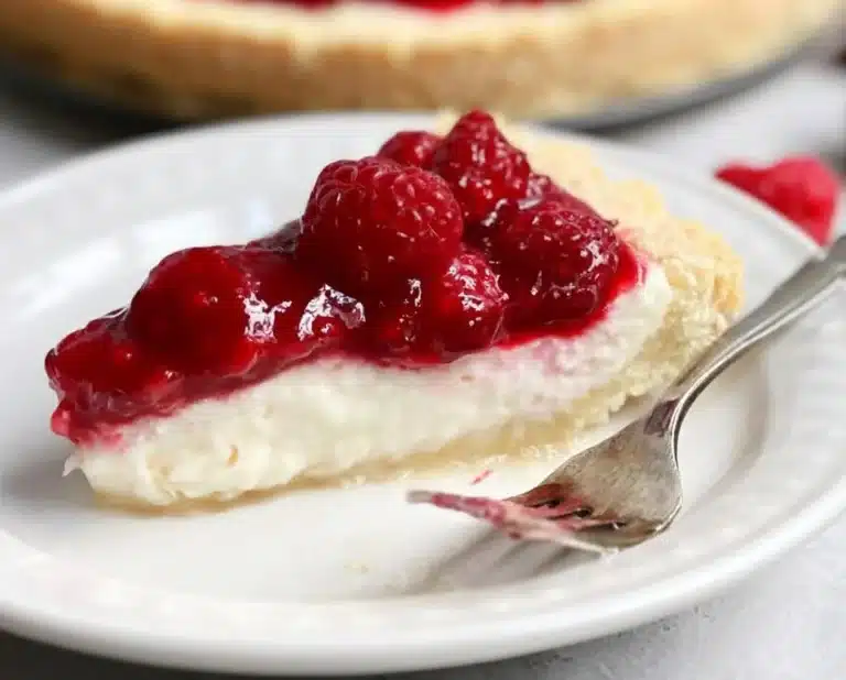 Slice of raspberry cream pie with fresh raspberries on top