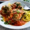 Plate of spinach feta turkey meatballs garnished with herbs