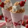 Strawberry cheesecake milkshake topped with whipped cream and strawberry slices.