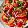 Colorful tomato salad with fresh herbs and vinaigrette dressing