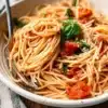 Delicious bowl of Tomato Spaghetti topped with fresh basil and Parmesan cheese