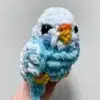 An adorable Pocket Parrot perched on a finger, showcasing its vibrant feathers and friendly nature.